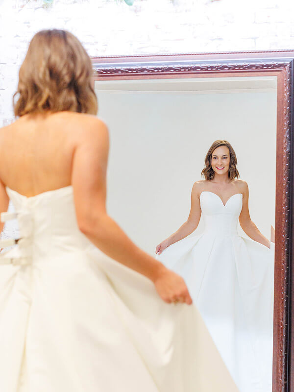 Bride looking at herself in a wedding dress